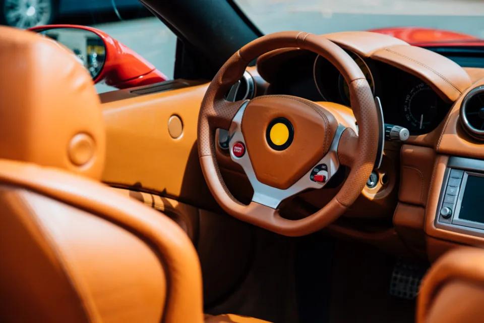Leather interior and steering wheel of a supercar, choosing the best luxury car rental company