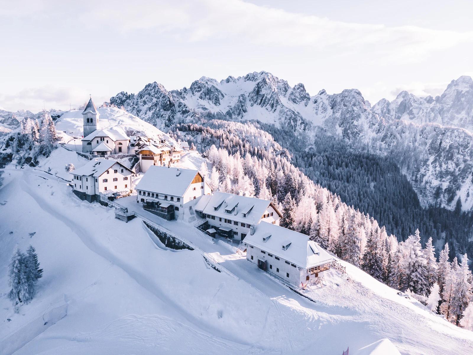 Snow-covered mountain village below Dolomite peaks