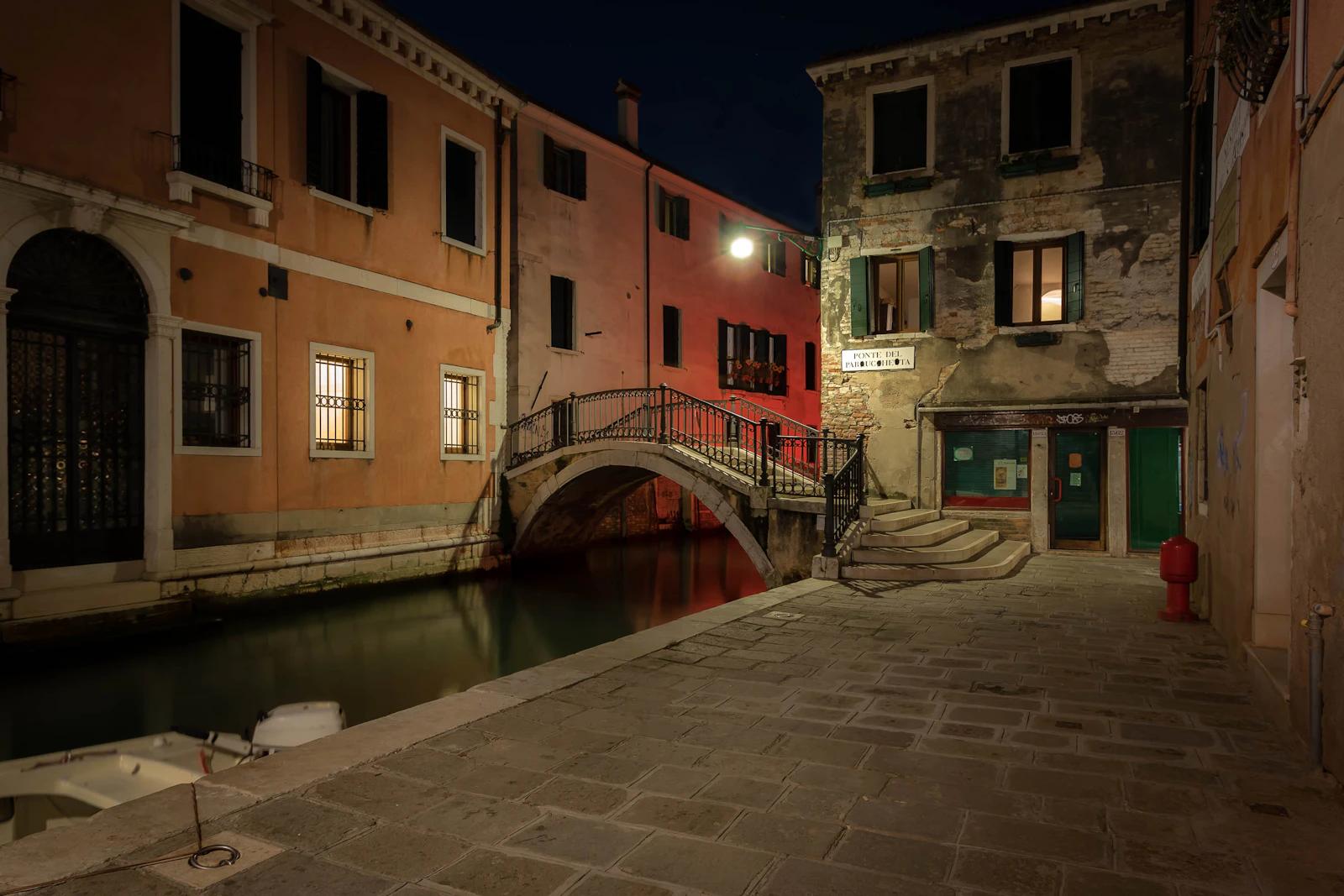 A quiet Venice canal and footbridge at night